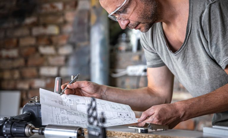 Industriarbetare läser av skiss