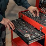 Male mechanic using tool box in hangar